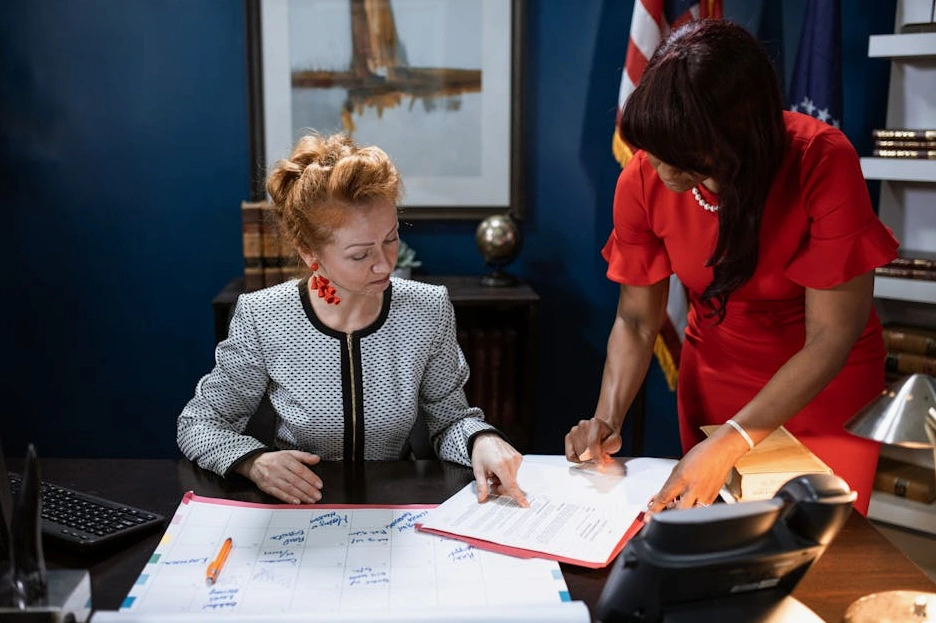A team of business executives strategically planning around a large digital display showing risk analytics.