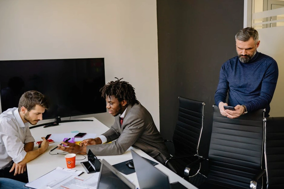 A diverse team of professionals in a bright, modern office collaborating around a table.